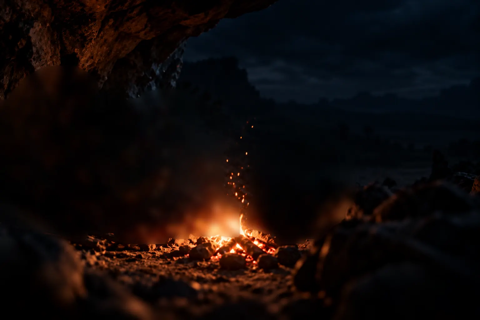 A small group of early humans sits close around a fire at the mouth of a rock shelter.